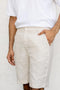 Person Classic Cream Shorts and a white shirt against a plain background Person Classic Cream Shorts and a white shirt against a plain background
