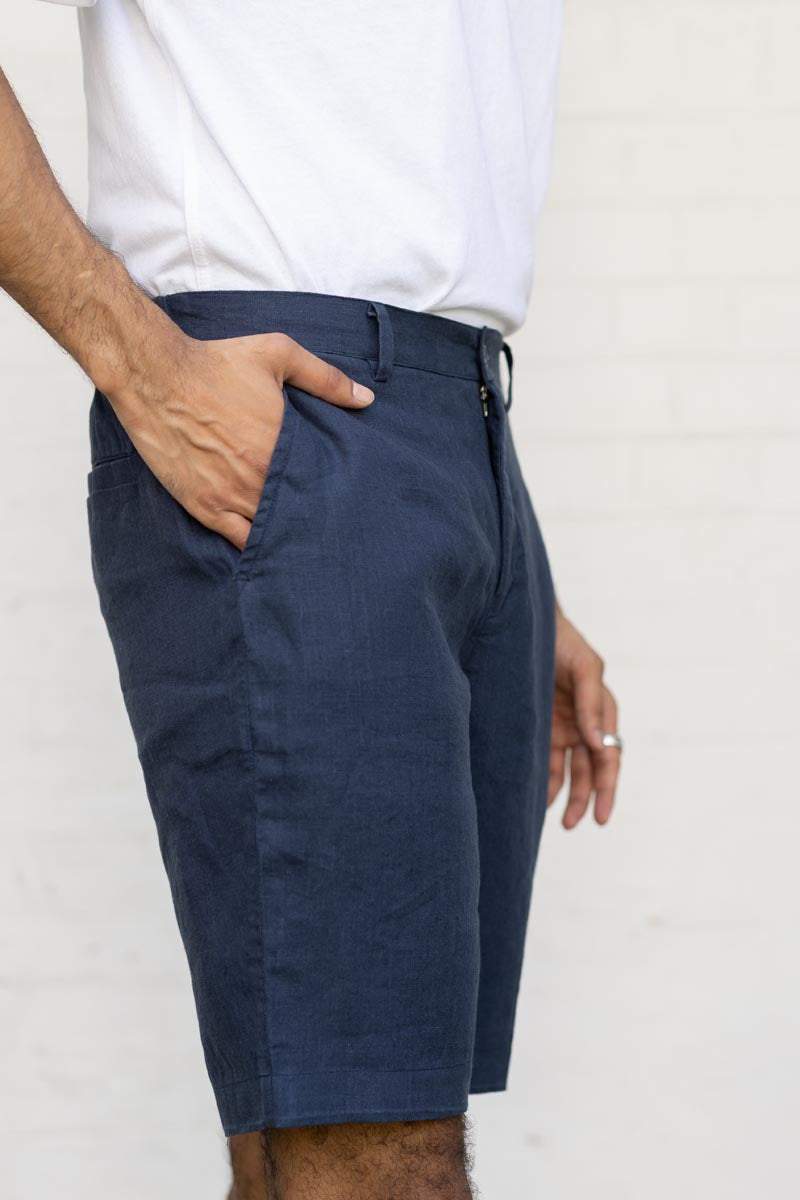 Person wearing Navy Blue Shorts with a white shirt on a plain background
