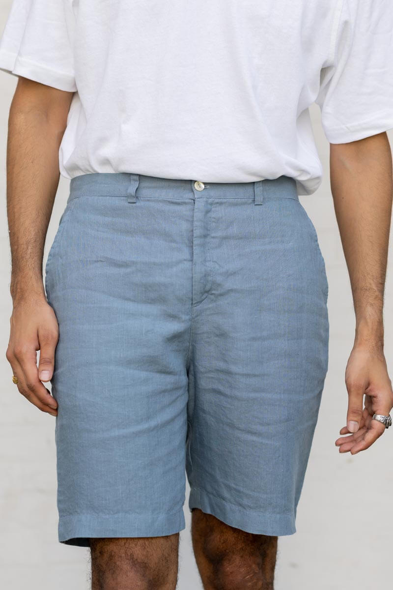 Person wearing Airforce Blue Shorts and a white shirt on a plain background