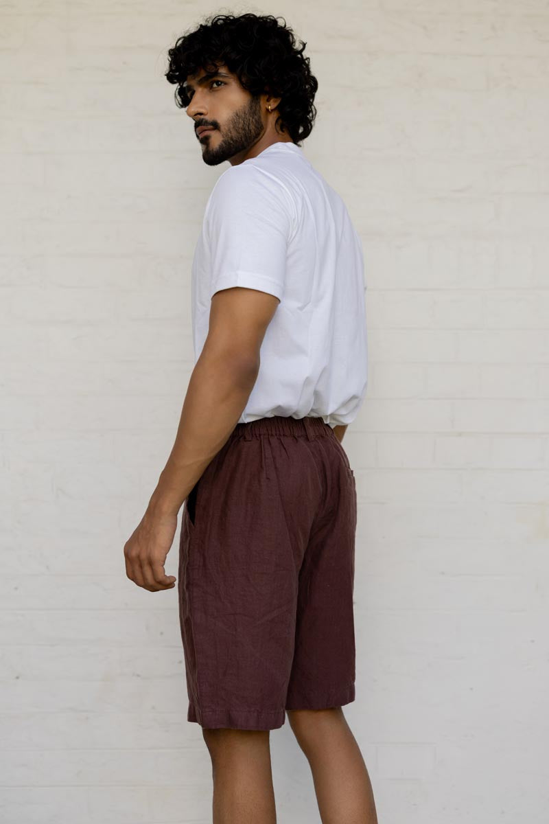 Man wearing a white t-shirt and Wine Shorts against a plain background