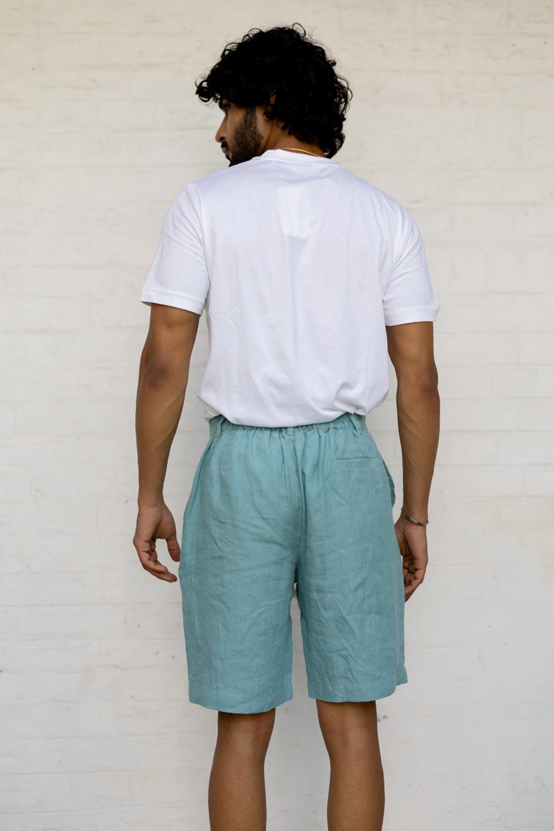 Person wearing a white t-shirt and Pine Green Shorts against a plain background