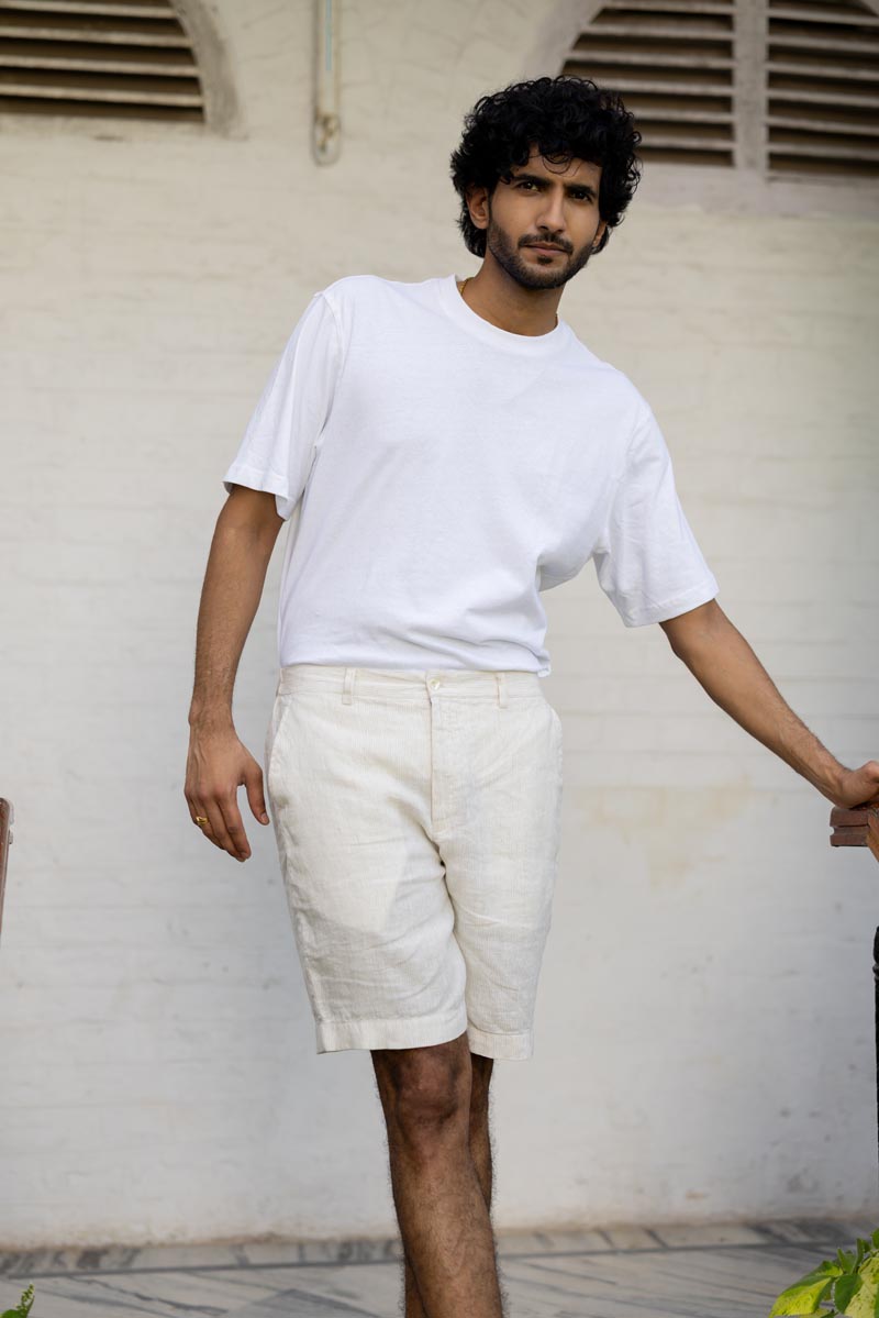 Man wearing a white t-shirt and Ivory Fine Stripe Shorts against a plain background