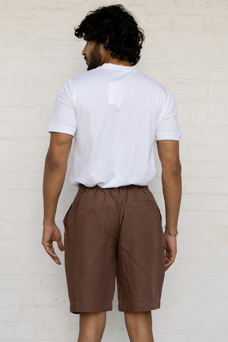 Man wearing a white t-shirt and Walnut Shorts against a light background