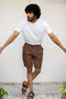 Man wearing a white t-shirt and Walnut Shorts against a light background