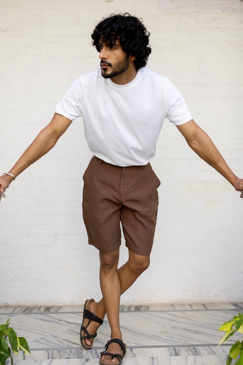 Man wearing a white t-shirt and Walnut Shorts against a light background