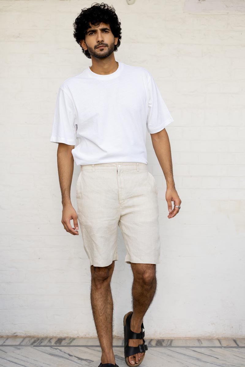 Man wearing a white t-shirt and Classic Cream Shorts against a light background