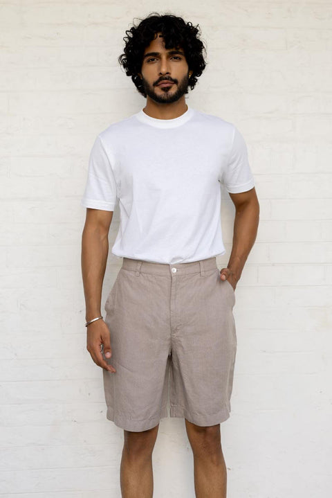 Man wearing a Almond Beige Shorts and White tshirt against a white background