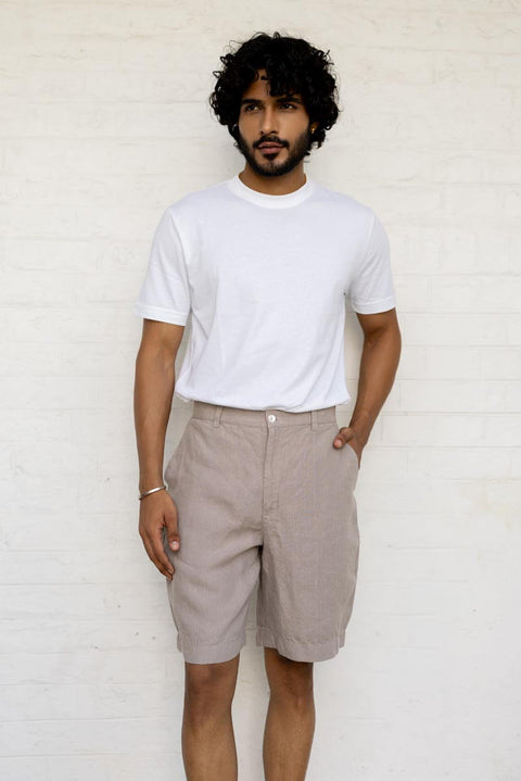 Man wearing a Almond Beige Shorts and White t-shirt against a white background