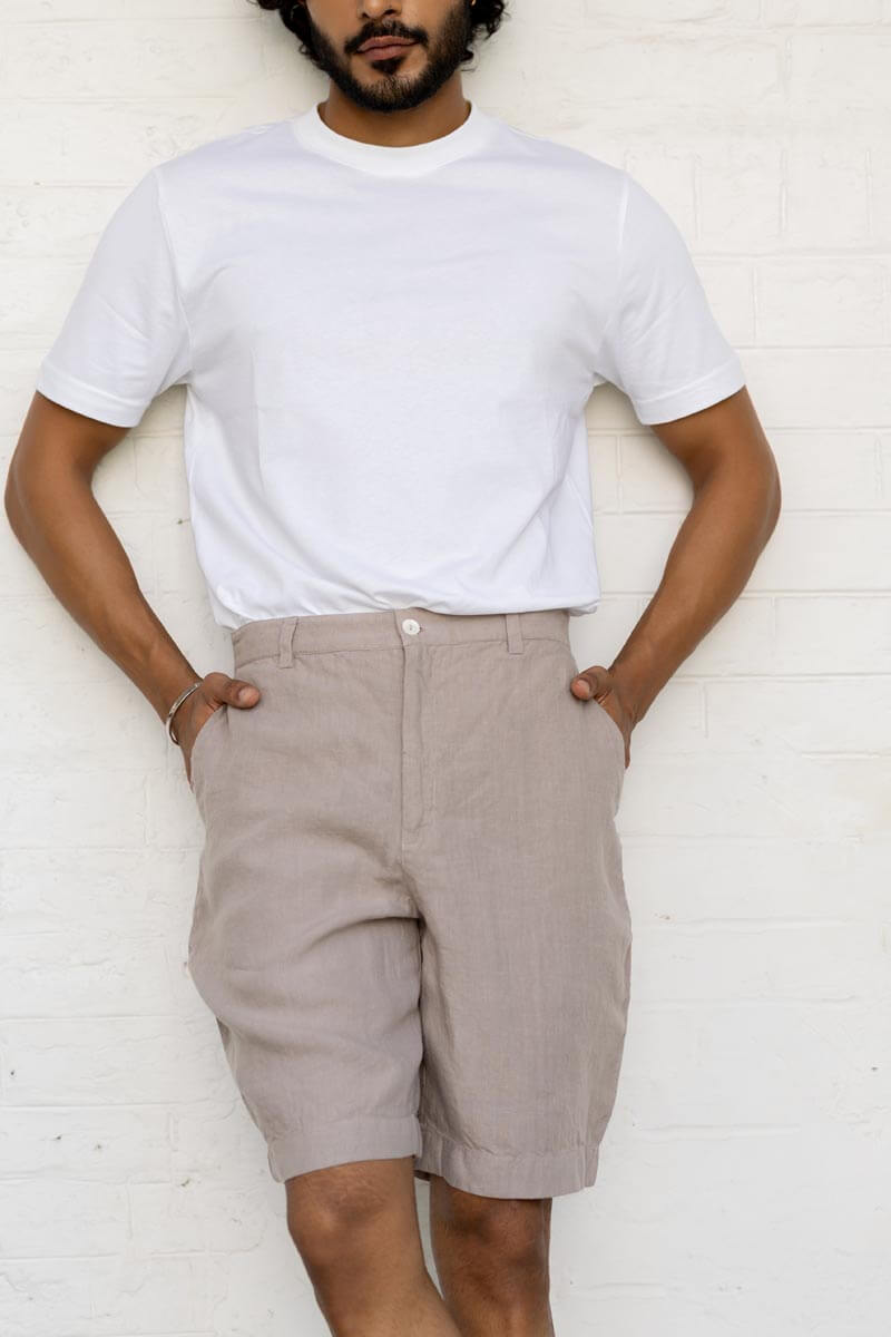 Man wearing a white t-shirt and Almond Beige Shorts against a white background