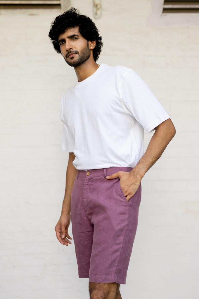 Man wearing a white t-shirt and Twilight Purple Shorts standing against a light-colored wall.
