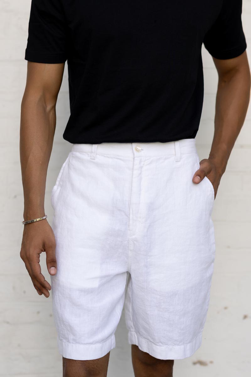 Person wearing a black t-shirt and White Shorts on a plain background