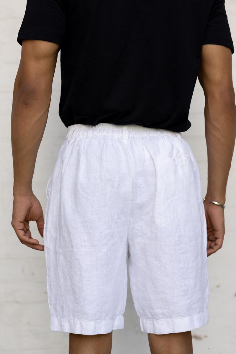 Person wearing White Shorts and a black shirt against a plain background