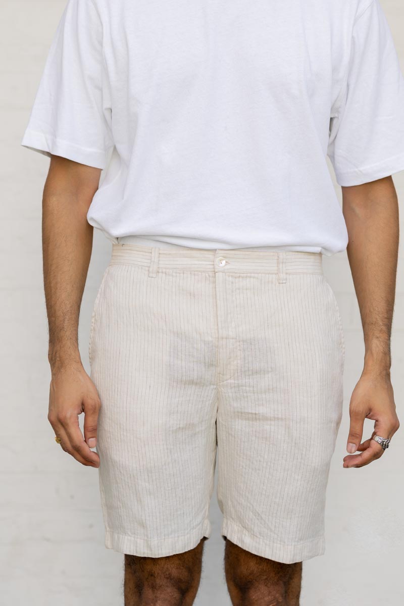 Person wearing a white t-shirt and Beige Hairline Stripe Shorts against a plain background