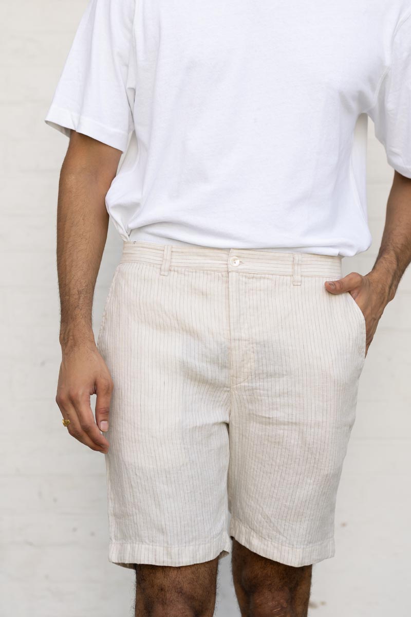 Person wearing Beige Hairline Stripe Shorts and a white shirt against a plain background