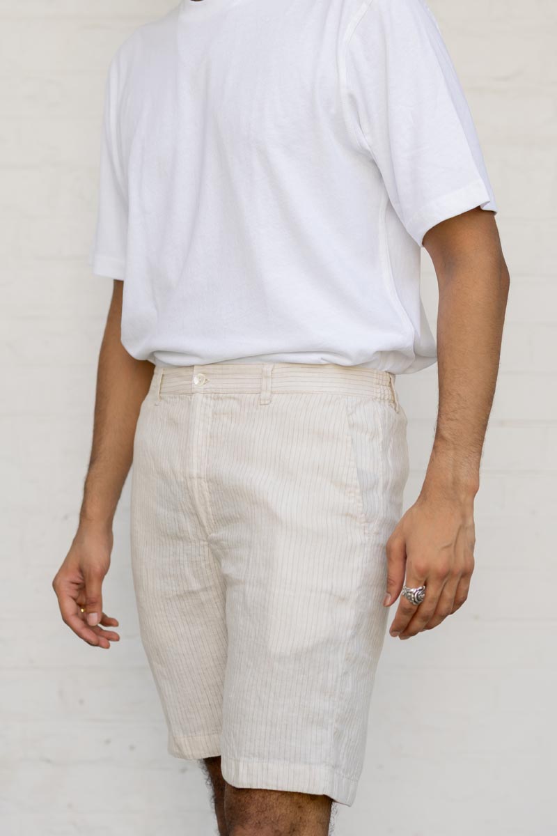 Person wearing a white t-shirt and Beige Hairline Stripe Shorts against a plain background