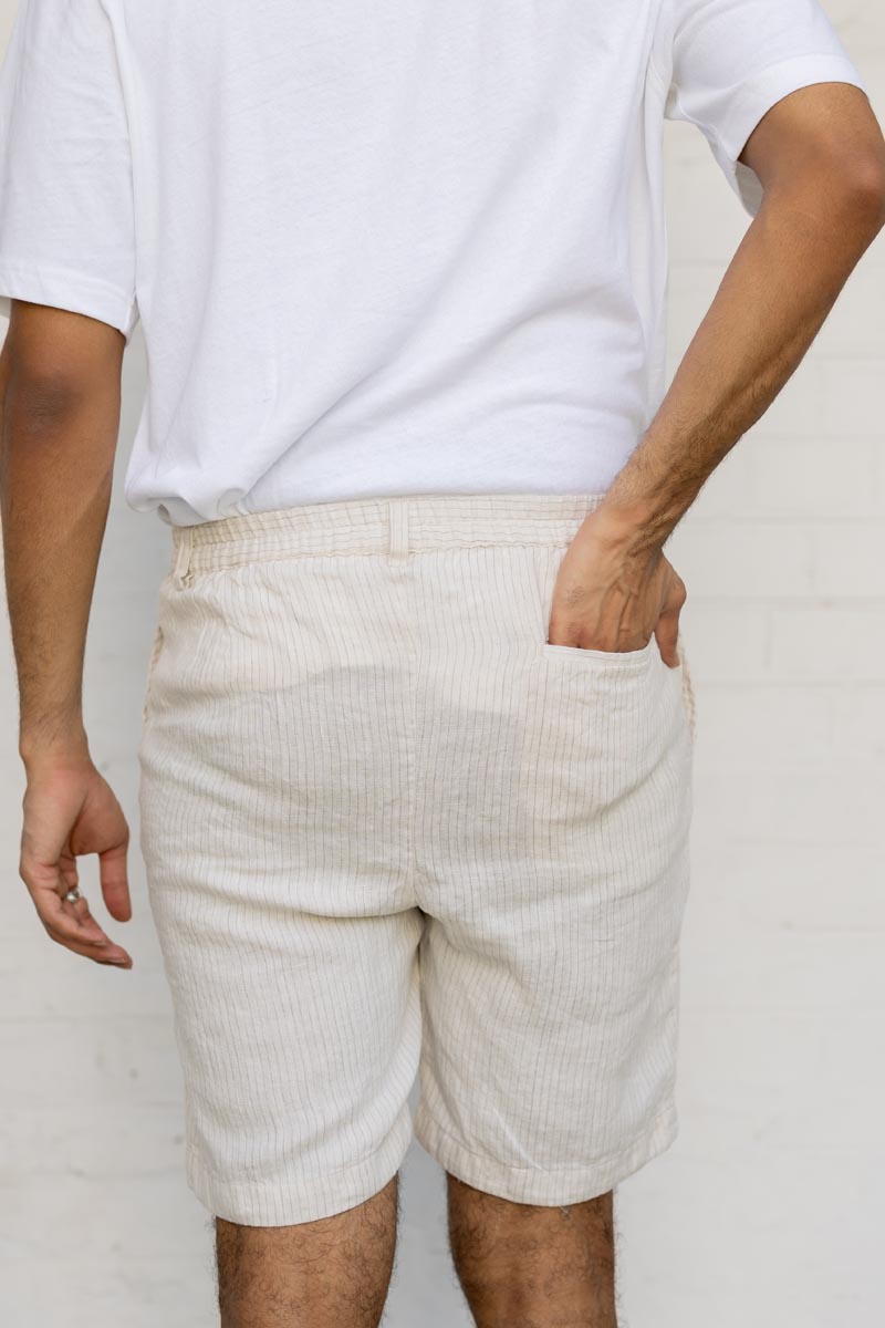 Person wearing Beige Hairline Stripe Shorts and a white t-shirt against a plain background