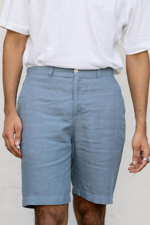 Person wearing Airforce Blue Shorts and a white shirt on a plain background