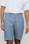 Person wearing Airforce Blue Shorts and a white shirt on a plain background
