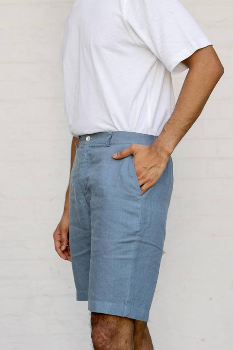 Person wearing Airforce Blue Shorts and a white shirt against a plain background