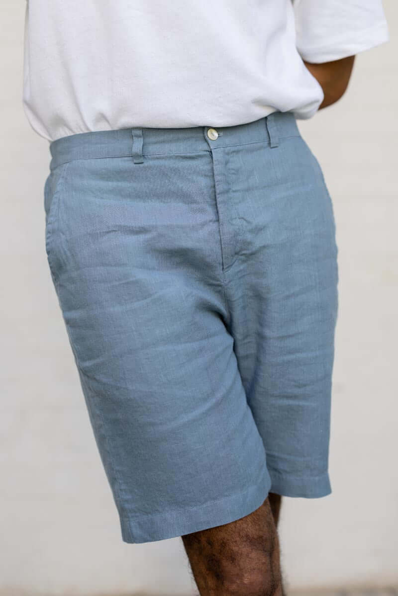 Person wearing Airforce Blue Shorts and a white shirt against a plain background