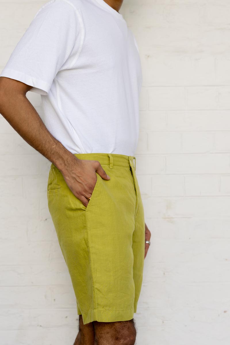 Person wearing a white t-shirt and Kiwi Green Shorts against a white background
