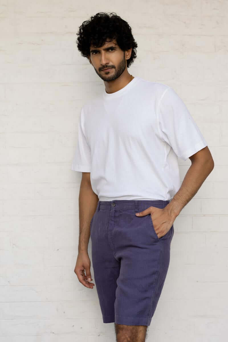 Man wearing a white t-shirt and Blueberry Shorts against a light background